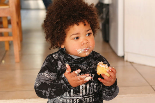 Toddler showing independence feeding himself.